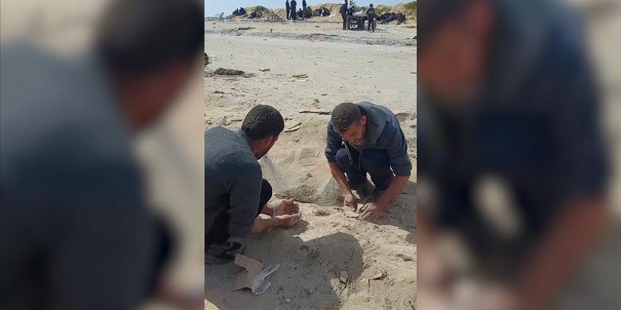 Gazzeliler, sahile dökülen yiyecekleri kumlar arasından toplamaya çalışıyor