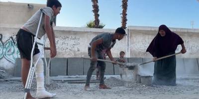 Gazzeli kadın, İsrail saldırılarında ölenler için yıkılan evlerin molozlarından kabir hazırlıyor